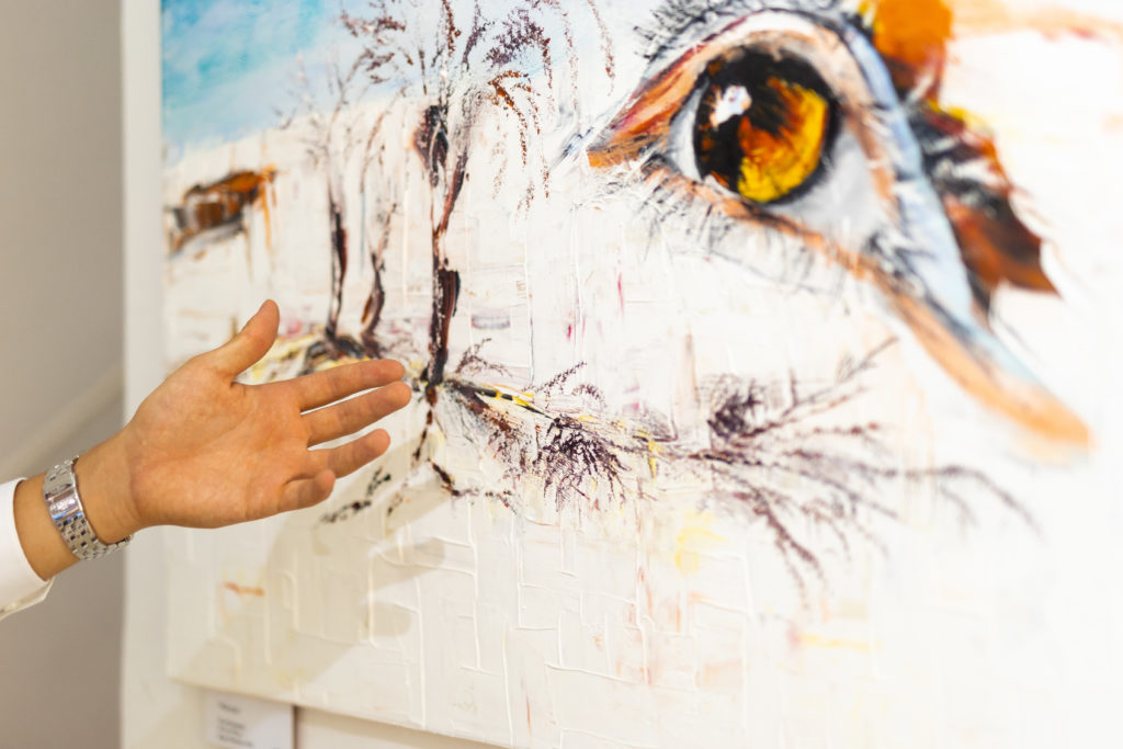 Besucher der Pop-Up Ausstellung im Gespräch über das Gemälde "White Sands" von Roger Ziereisen